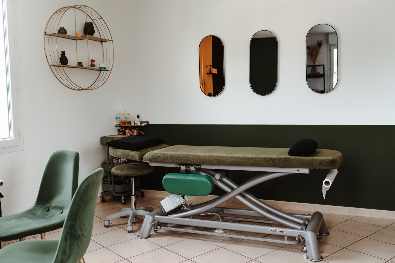 Salle de soin aux miroirs ovales et mur vert sapin
