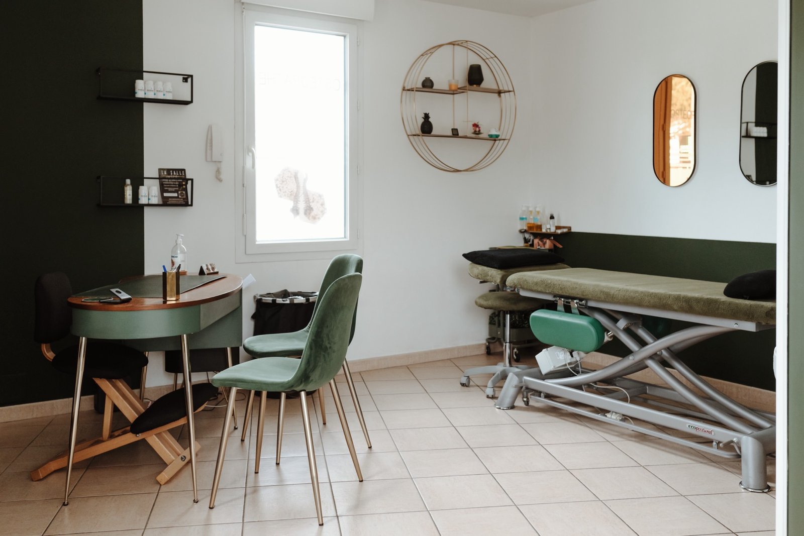 Vue d'ensemble du cabinet : bureau, chaises en velours vert et table de soin